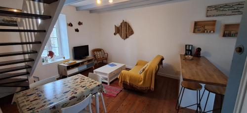 una pequeña sala de estar con cocina y sala de estar. en Le Gîte de l'Amer - T2 - Duplex - Centre Bourg, en Baden