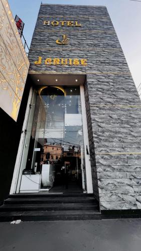 ルディヤーナーにあるHotel J Cruise Newの看板が掲げられた建物の正面玄関
