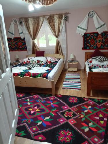a bedroom with two beds and a rug at Casa Alina Breb in Breb