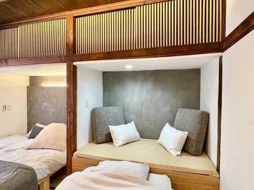 東京にある和みの宿Rent the whole houseのベッド2台と椅子2脚が備わる客室です。