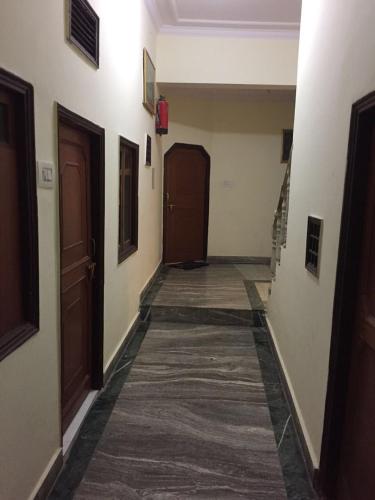 an empty hallway with two doors and a carpet at Gautama Hotel in Khajurāho