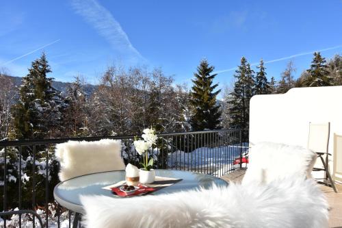 a table and chairs on a balcony with snow at Wellness Aparthotel Panorama Alpin - Ferienwohnungen Jerzens im Pitztal in Jerzens