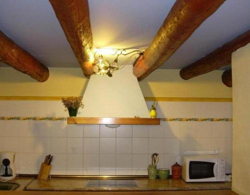 a kitchen with a ceiling fan and a microwave at Casa El Rey in Murillo de Gállego