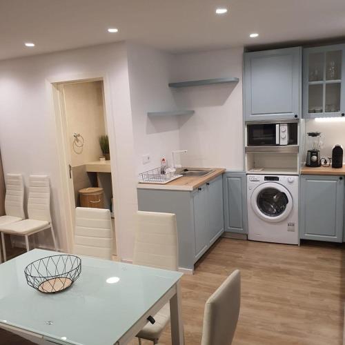 a kitchen with a table and a washing machine at Center Marina View Brown Studio in Funchal