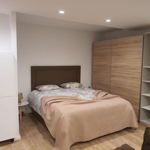 a bedroom with a large bed with a wooden headboard at Center Marina View Brown Studio in Funchal