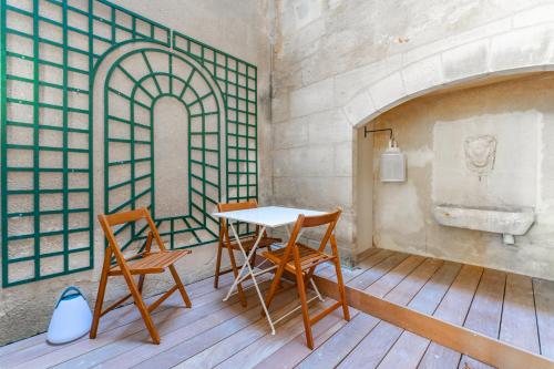 a table and two chairs in a room with a fireplace at Élégant appartement Place du Parlement pour 4 personnes in Bordeaux
