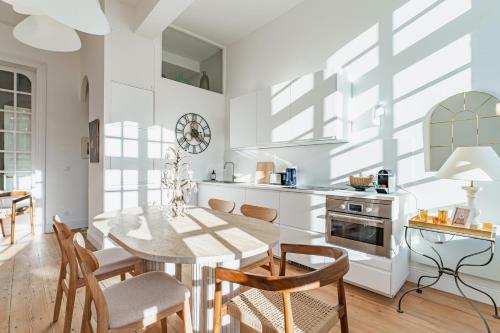 a kitchen with a table and chairs in a room at Élégant appartement Place du Parlement pour 4 personnes in Bordeaux