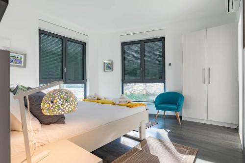 a bedroom with a bed and a blue chair at Korcula Luxury Apartments in Korčula