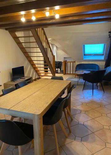 une salle à manger avec une table et des chaises en bois dans l'établissement Magnifique Duplex à 600m du Martroi, à Orléans