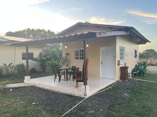 a small house with a porch with a table at Hotel VILLAS DON PABLO LAS TABLAS in Las Tablas
