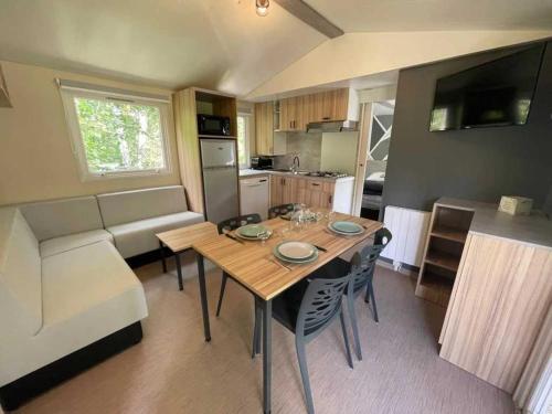 een keuken en eetkamer met een tafel en een bank bij Camping 3 étoiles - Piscine - eehhec in Landry