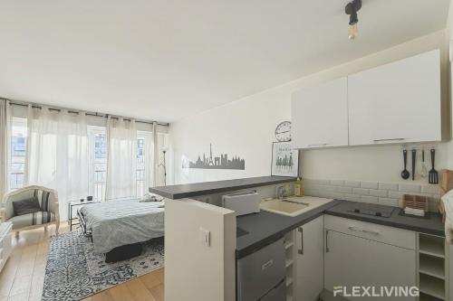 - une cuisine avec évier et un lit dans une chambre dans l'établissement Flexliving - Studio - Piver, à Paris