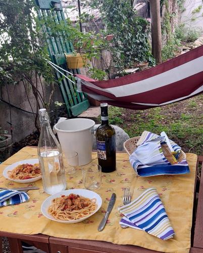 a table with plates of pasta and a bottle of wine at La casa di Zia Mimina in Civitella Casanova