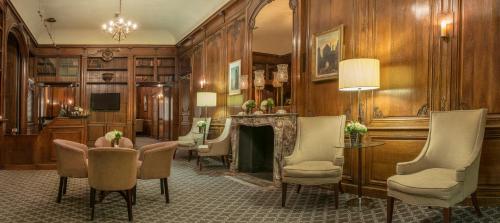 a lobby with a fireplace and chairs and a fire place at De Vere Horsley Estate in Leatherhead