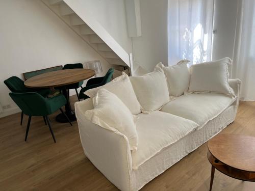a living room with a white couch and a table at La petite maison in Souvigny-en-Sologne
