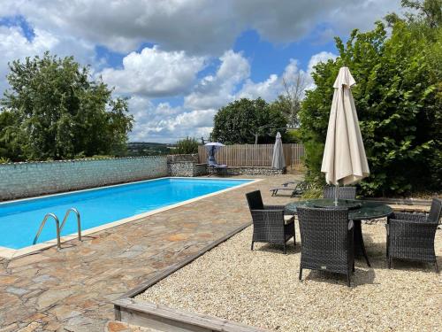 - une table avec un parasol à côté de la piscine dans l'établissement Beautiful Gite, Private Pool, Magnificent views!!!, à Nanteuil-Auriac-de-Bourzac