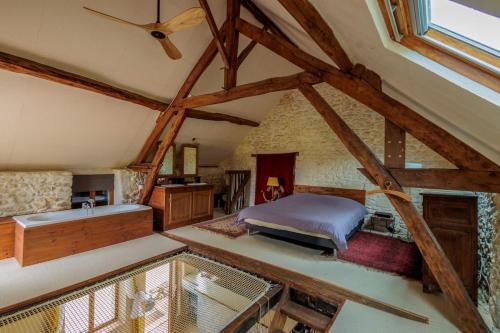 - une chambre mansardée avec un lit et une baignoire dans l'établissement Maison de charme proche Sancerre avec piscine, à Groises