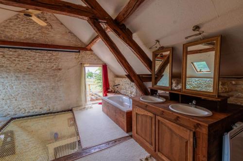 une salle de bain avec deux lavabos et un grand miroir dans l'établissement Maison de charme proche Sancerre avec piscine, à Groises