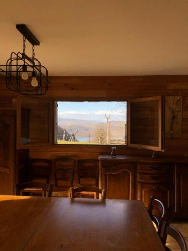 une salle à manger avec une table et des chaises et une fenêtre dans l'établissement Gite La Grange sur les Bois, à Aiguebelette-le-Lac