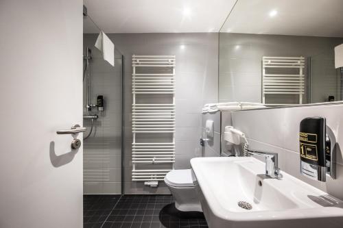 a bathroom with a sink and a toilet at Hotel Irschenberg Süd in Irschenberg