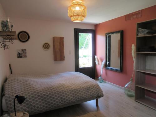 une chambre avec un lit et un miroir au mur dans l'établissement Un havre de paix en Périgord, à Fanlac