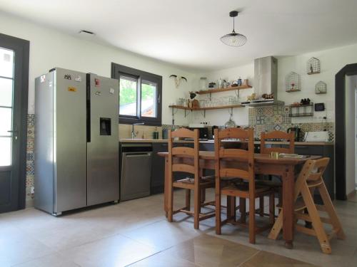 La cuisine est équipée d'une table, de chaises et d'un réfrigérateur. dans l'établissement Un havre de paix en Périgord, à Fanlac