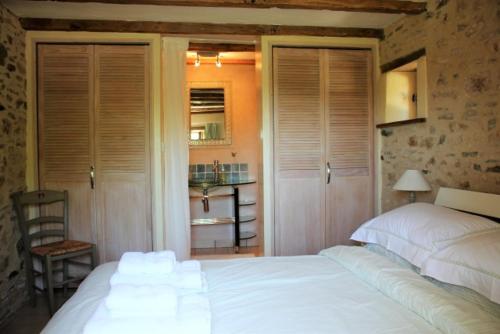 a bedroom with a large white bed and a chair at Gites at Le Tilleul - Le Pommier in Le Lindois
