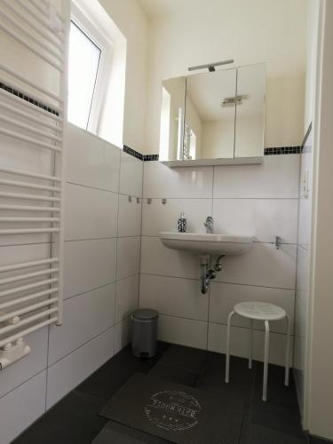a bathroom with a sink and a mirror and a stool at Ferienwohnung Stargard in Burg Stargard