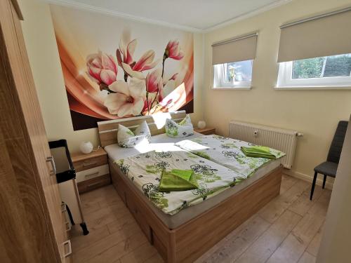 a bedroom with a bed with a flower painting on the wall at Ferienwohnung Stargard in Burg Stargard