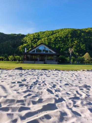 a house on the beach with a sandy beach in front at Ciucea185 -Casa din Livadă in Ciucea