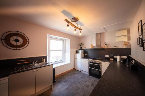 a kitchen with white appliances and a window at 9A Bayfield Road in Portree
