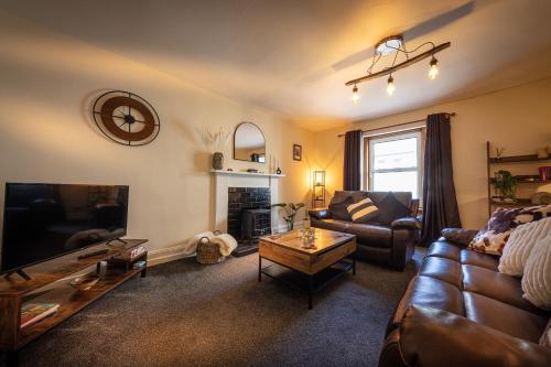 a living room with a couch and a tv at 9A Bayfield Road in Portree