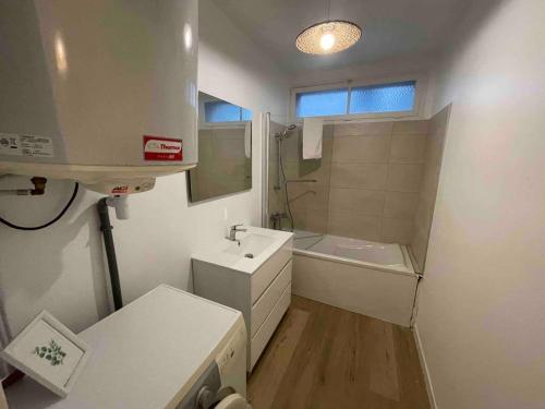 une salle de bain avec un lavabo, des toilettes et une baignoire dans l'établissement Agréable logement 8 personnes, à Chalon-sur-Saône