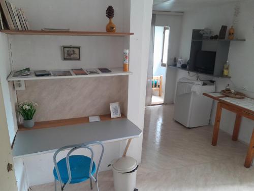 - un salon avec un bureau et une chaise bleue dans l'établissement Appartement privatif en bord de rivière, à Figeac