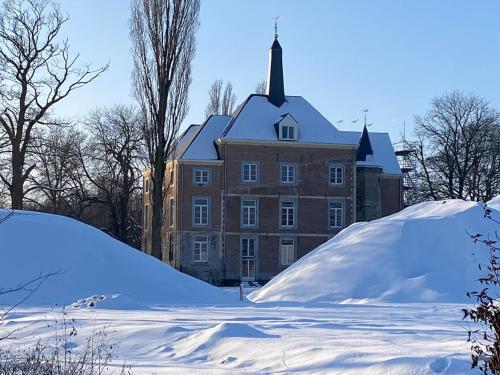 a large building with a pile of snow in front of it at BelleVie Apartment, Eijsden-Maastricht in Eijsden