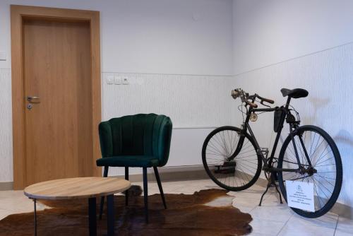 a bike parked next to a green chair in a room at Gostišče Pod Kostanji in Dobrna