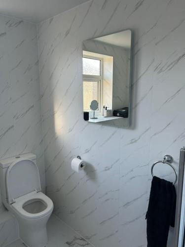 a white bathroom with a toilet and a mirror at Peak District - 2 Beds - Sleeps 4 - Pet Friendly in Chesterfield