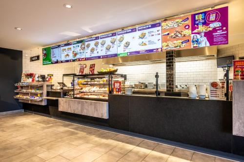 a fast food restaurant with a counter with food at Hotel Irschenberg Süd in Irschenberg