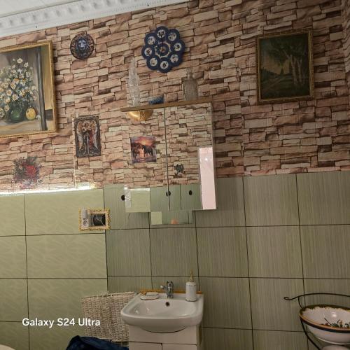 a bathroom with a sink and a stone wall at Apartament Wilhelma II in Ząbkowice Śląskie