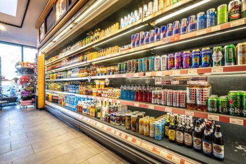 a grocery store aisle with lots of drinks on shelves at Hotel Irschenberg Süd in Irschenberg