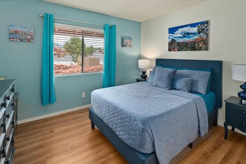 a blue bedroom with a bed and a window at La Casa De Camilla in Sedona