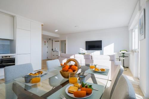 a dining room and kitchen with a table with oranges on it at Sunset Horizon Carcavelos in Carcavelos
