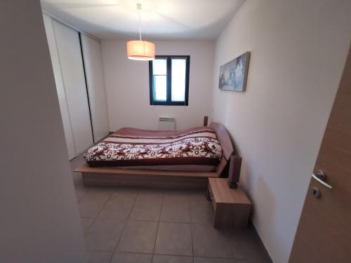 une petite chambre avec un lit dans le coin dans l'établissement Appartement traversant, à Folelli