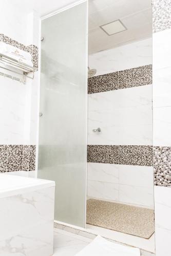 a shower with a glass door in a bathroom at Asmara Hotel in Lusaka