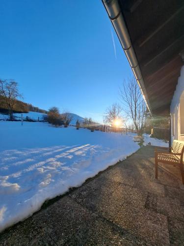 a snow covered yard with a bench on a house at Ferienhaus Willingen Diemelsee in Diemelsee