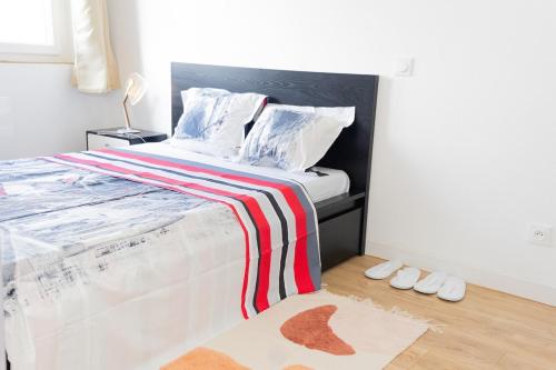 een slaapkamer met een bed met een rood-witte deken bij The Zen Space in Athis-Mons