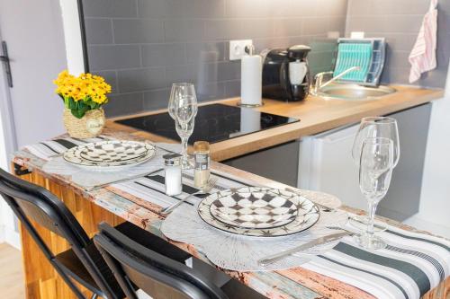 een keuken met een tafel met borden en wijnglazen bij The Zen Space in Athis-Mons