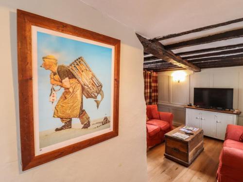 a painting of a man walking in a living room at Driftwood Cottage in Harwich