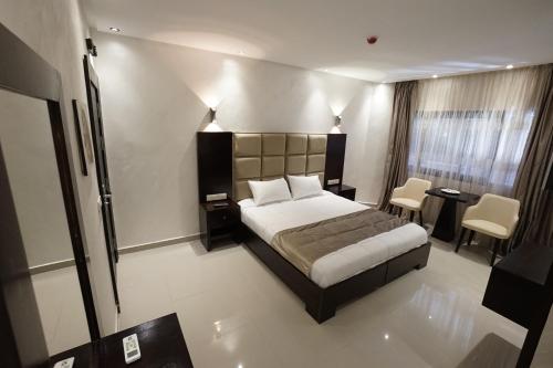 a bedroom with a bed and a table and chairs at Hotel nord kap in M'diq