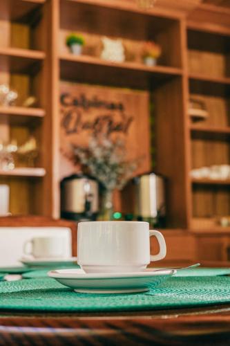 a table with two coffee cups and plates on it at Cabinas El Quetzal in San Gerardo de Dota